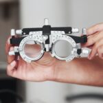 Focused photo. Female hands holding the optical device for eye testing